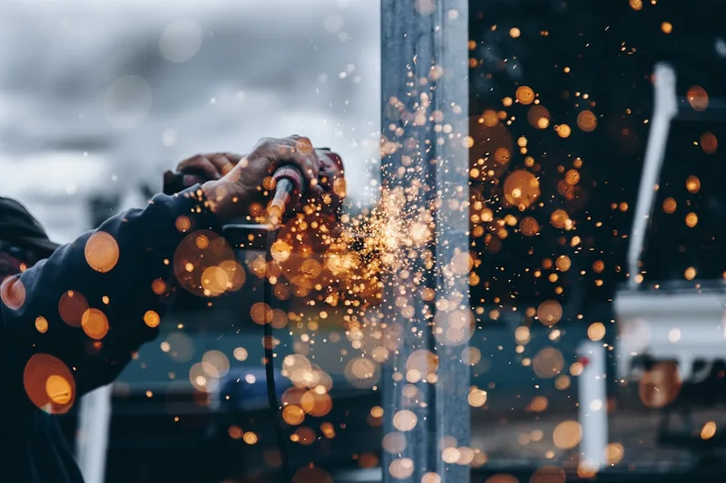 Un artisan au travail, dans une gerbe d'étincelles